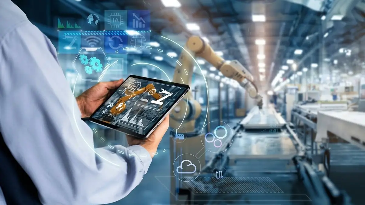 IA en la industria: técnico con una tableta con interfaz de inteligencia artificial en una planta industrial con brazo robótico